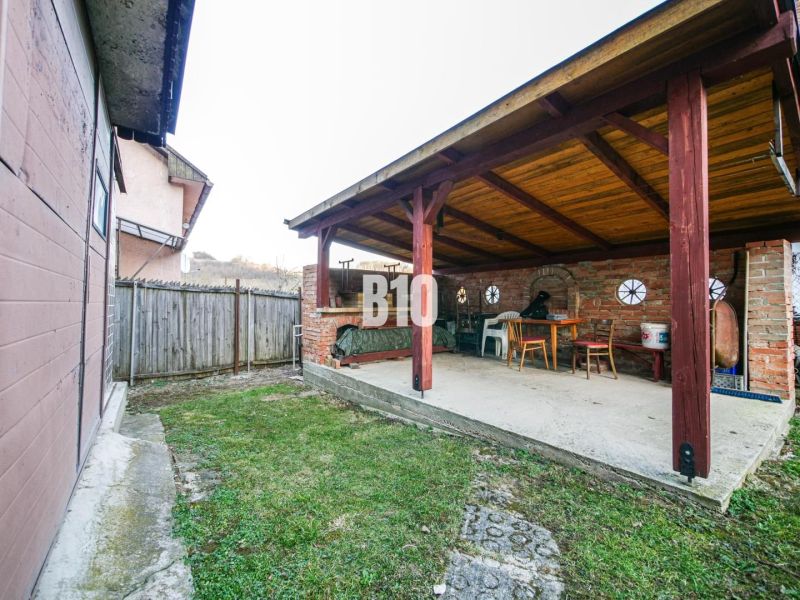 Zastřešená terasa s posezením a dřevěnými prvky u rodinného domu v Trenčianských Teplicích.