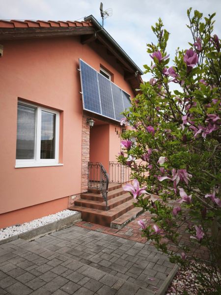 Rodinný dům na Hlavní ulici v Martin nad Žitavou se solárními panely a magnólií.