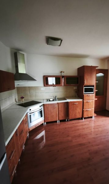 Kuchyně s dřevěným dekorem, vestavěné spotřebiče a rohové skříňky v rodinném domě.