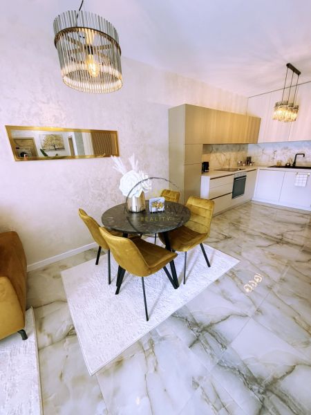 Jídelní část v 2-pokojovém bytě s mramorovou podlahou a elegantním osvětlením.