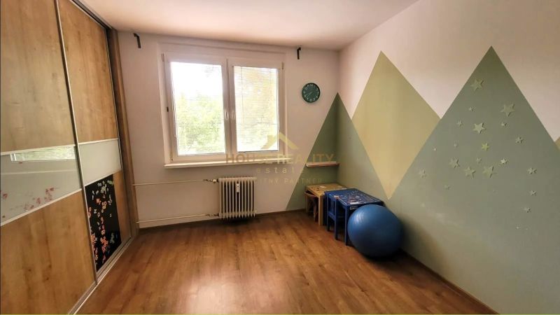 Dětský pokoj ve 3-pokojovém bytě s podlahou s dřevěným dekorem a kreativní stěnou.