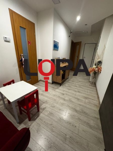Interiér obchodních prostor s podlahou s dřevěným dekorem a dětským koutkem.