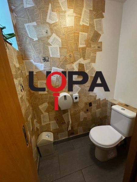 Interiér toalety s kreativní papírovou dekorací stěny v obchodních prostorách.