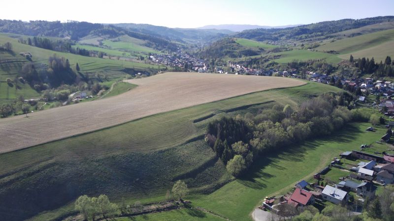 Krajina v Čiernom Balogu se zemědělskými a lesními pozemky na svazích kopců.