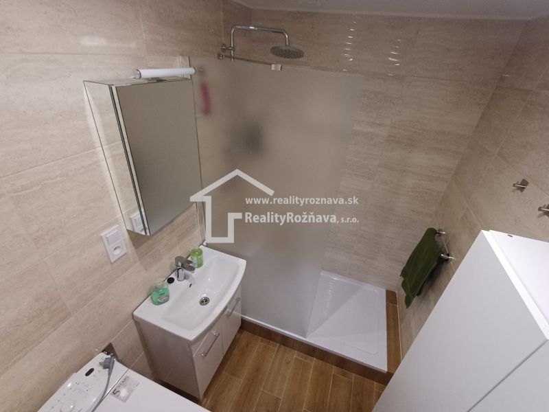 Koupelna ve 3pokojovém bytě s toaletou, sprchovým koutem a podlahou s dřevěným dekorem.