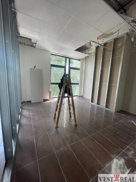 Kanceláře s žebříkem a rozestavěným podhledem, podlaha s dřevěným dekorem.