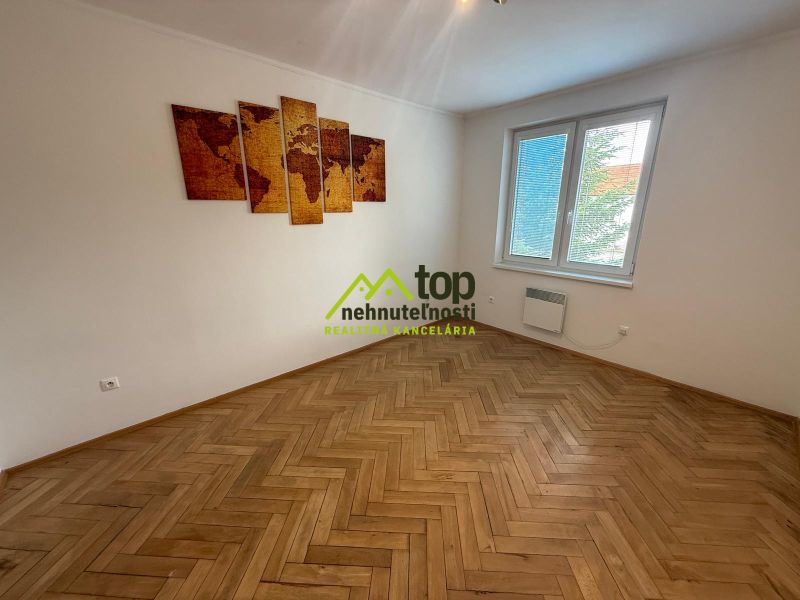 Pokoj v 2pokojovém bytě s mapou na stěně a podlahou s dřevěným dekorem.