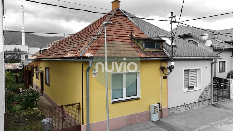 Rodinný dům v Martině se šikmou střechou a žlutou fasádou.