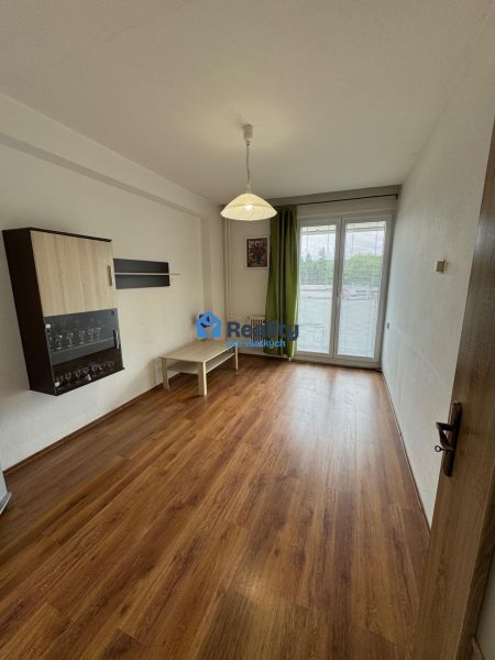 Obývací pokoj v 2pokojovém bytě s podlahou s dřevěným dekorem a balkonem.