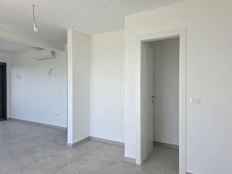 Bílá místnost ve 4-pokojovém bytě s klimatizací a keramickou podlahou.