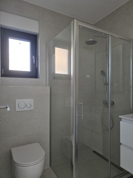 Koupelna se skleněným sprchovým koutem a WC ve 4-pokojovém bytě.