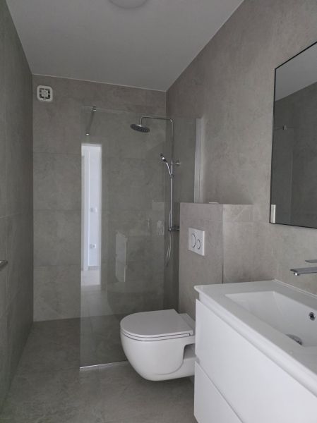 Koupelna se sprchovým koutem, umyvadlem a WC ve 4pokojovém bytě.