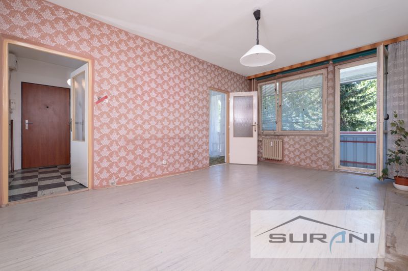 Interiér 4-pokojového bytu s tapetami a výhledem na balkon.