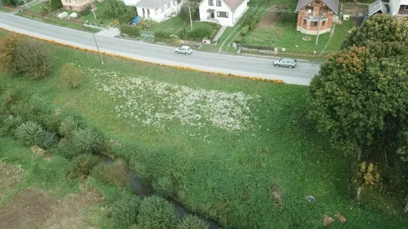 Letecký pohled na pozemky pro bydlení ve Slovenské Volové u cesty a domu.