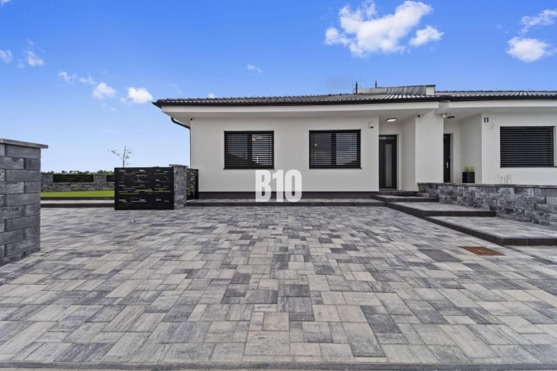 Rodinný dům v Nitře s kamennou dlažbou a jednoduchým exteriérovým designem.