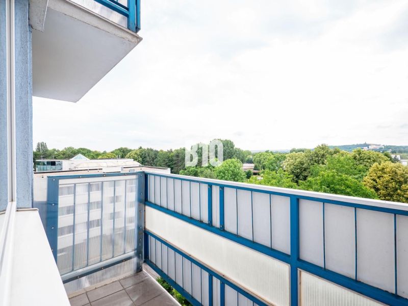 Balkon 3-pokojového bytu v Nitře s výhledem na zeleň a střechy budov.