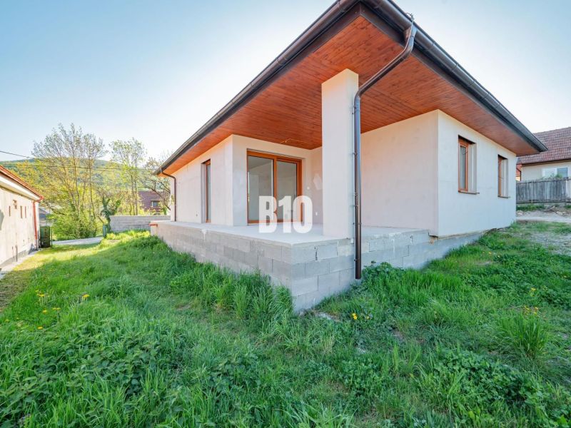 Rodinný dům v Nitře s betonovou terasou a zeleným trávníkem v zahradě.