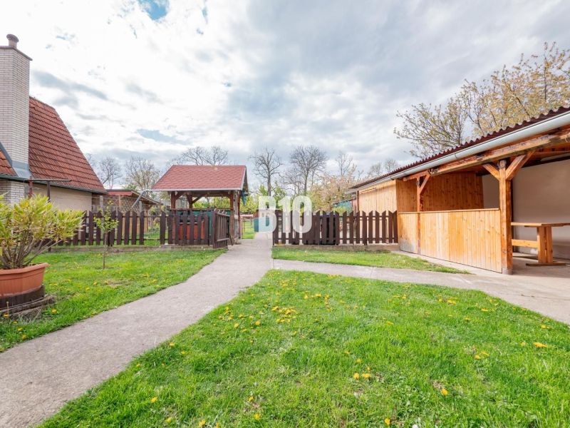 Nitra, rodinný dům, zahrada s dřevěným altánem, chodníkem a oplocením.