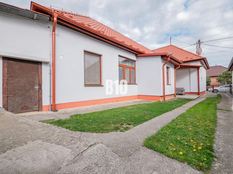 Rodinný dům v Nitře s červenou střechou, dvorem a jednoduchou zahradní úpravou.
