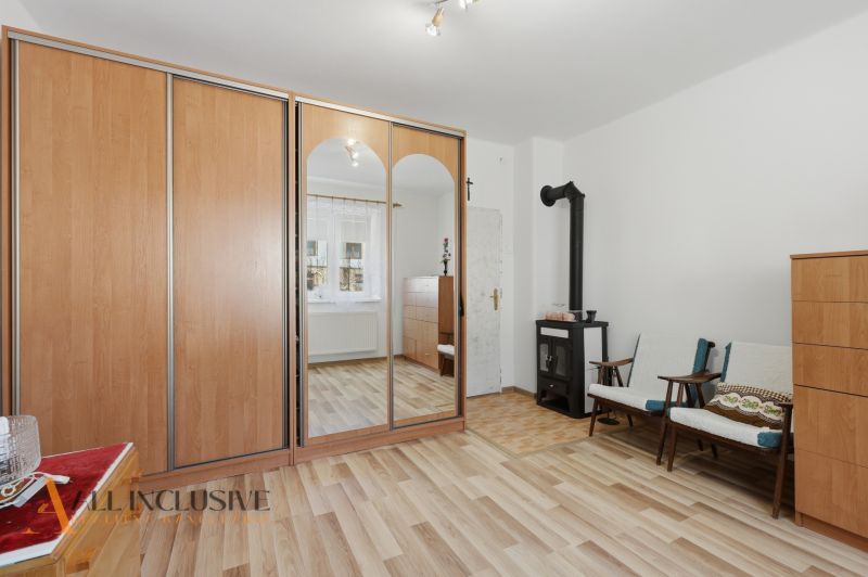 Pokoj v rodinném domě s krbem, skříní a podlahou s dřevěným dekorem.