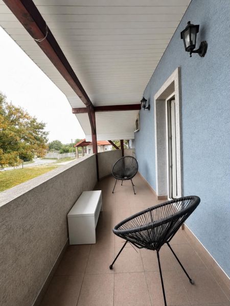 Balkon s černými židlemi a modrou stěnou ve 2-pokojovém bytě v Horním Baru.