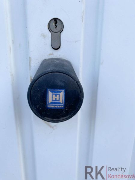 Zámek a klika na bílých dveřích v garážích na Belanské v Košicích.