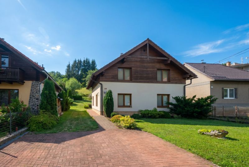 Rodinný dům v Horní Lehotě obklopený zahradou s trávníkem a příjezdovou cestou.