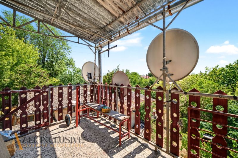 Balkon rodinného domu v Bodze se satelity a zelení v pozadí.