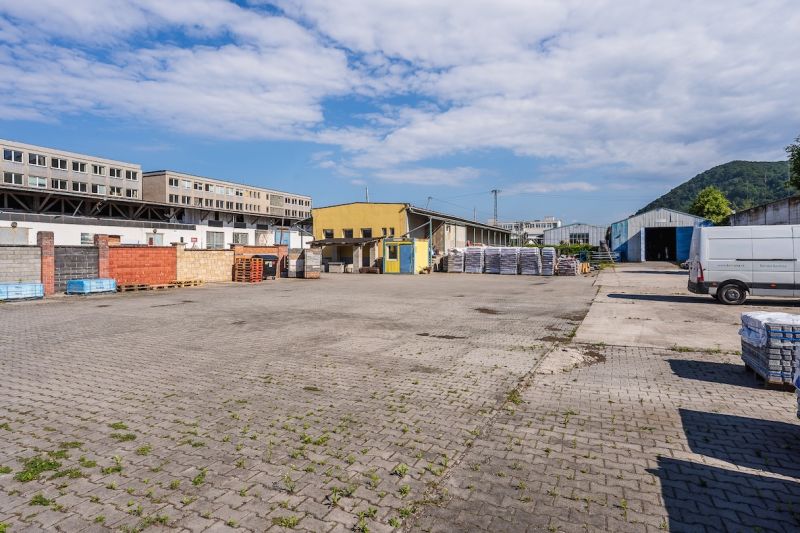 Budova na Zvolenské cestě v Banské Bystrici s venkovním skladovým prostorem a dlažbou.