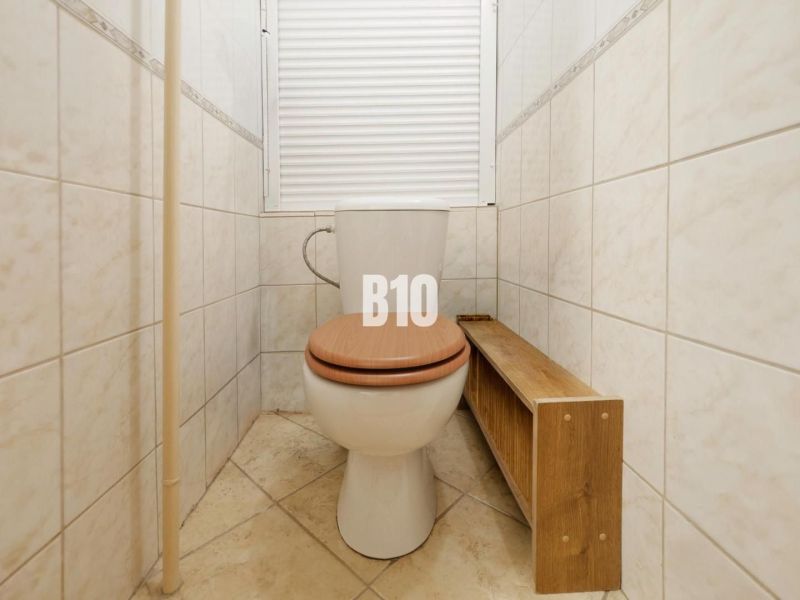 Koupelna se záchodem a podlahou s dřevěným dekorem v 2-pokojovém bytě.