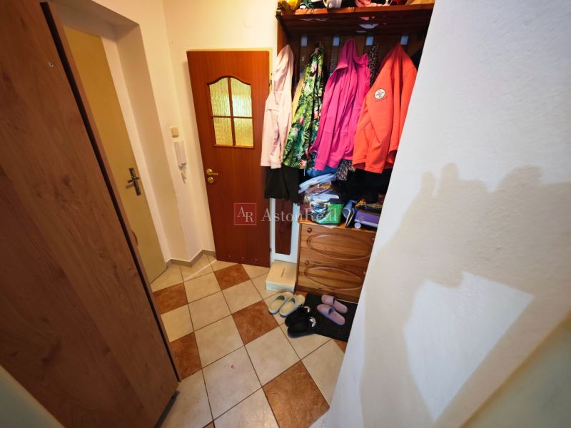 Chodba s dlažbou a šatní skříní ve 2pokojovém bytě.