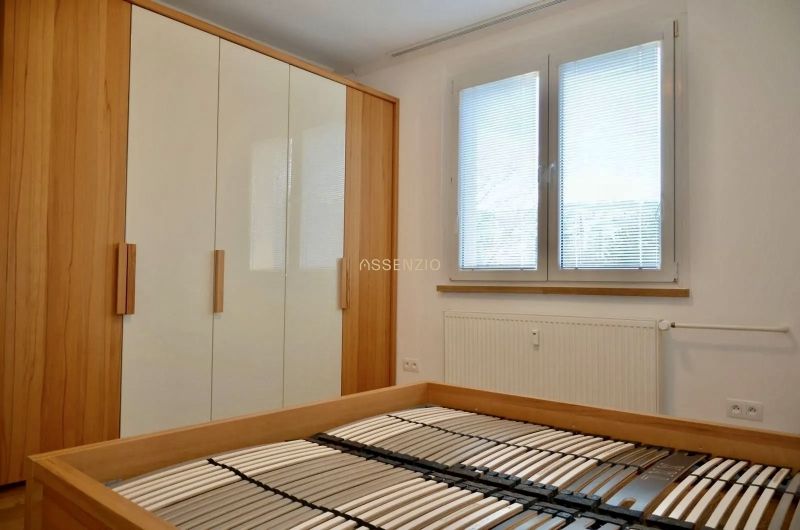 Ložnice s postelí bez matrace, vestavěnou skříní a oknem, 3pokojový byt.