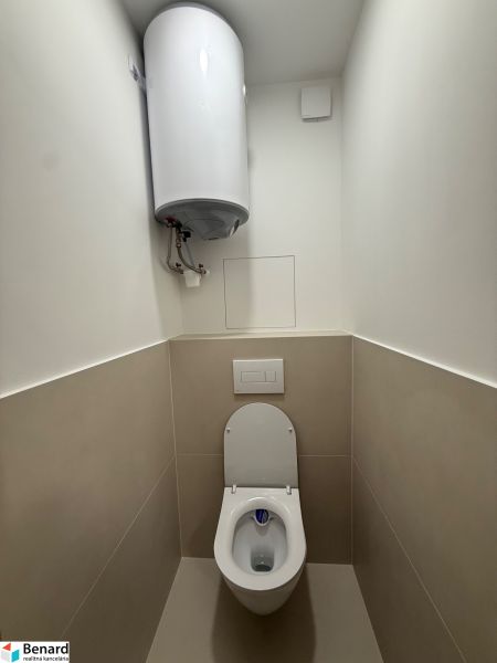 Toaleta se závěsným WC a bojlerem ve 3pokojovém bytě.