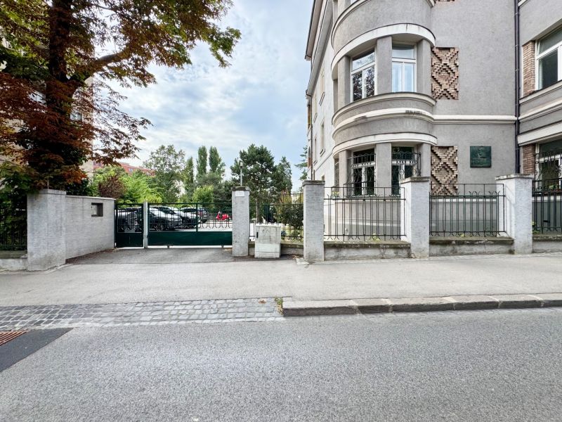 Budova na Palisádách v Bratislavě - Starém Městě s ozdobným zdivem a stromy kolem.