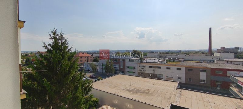 Pohled na městskou panorámu Lučence s budovami ze střechy 1-pokojového bytu.