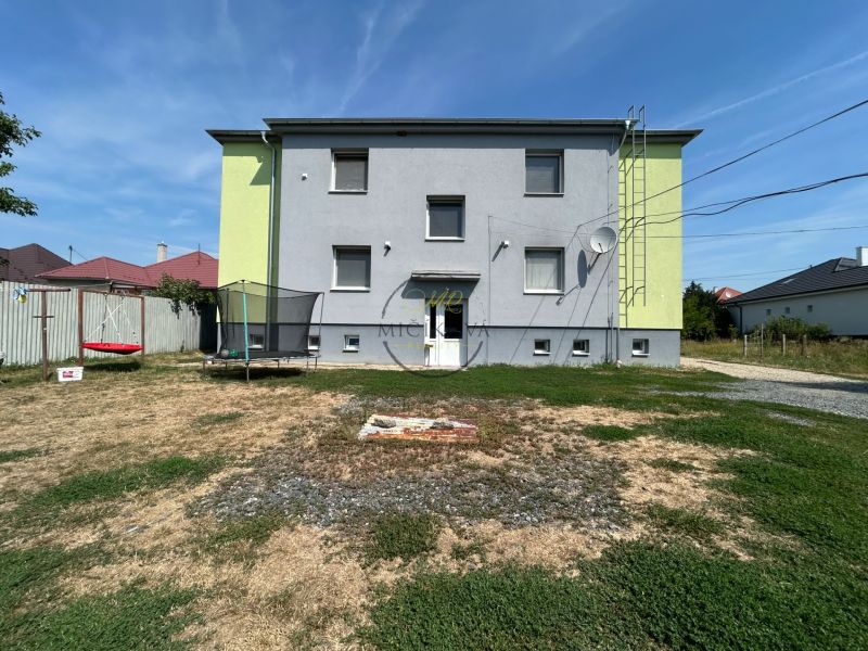 Dvoupatrová budova v Telincích s dvorem, trampolínou a houpačkou.