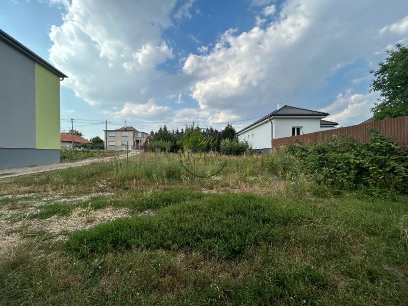 Zahrada v okolí domů v Telinciach s proměnlivou oblačností na obloze.