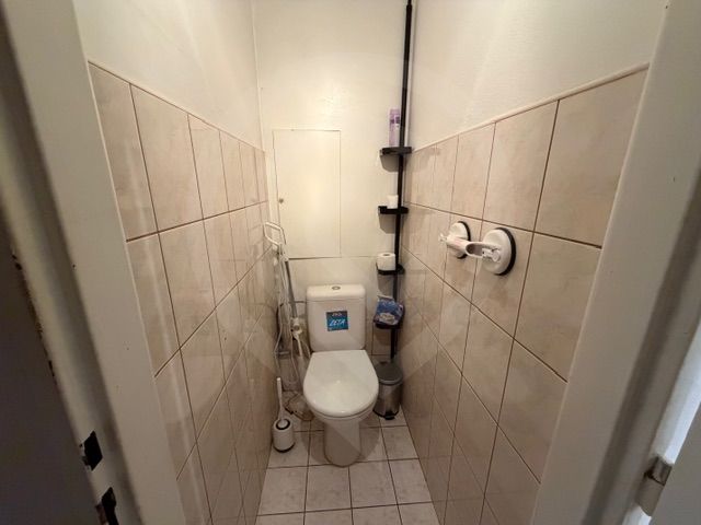 Toaleta s dlažbou a obklady ve 3-pokojovém bytě.