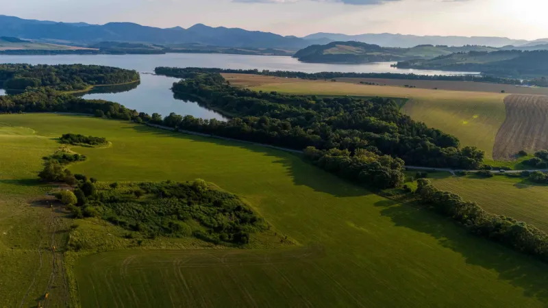 Krajina u Liptovského Trnovce se zvláštními nemovitostmi, obklopená loukami a lesy.