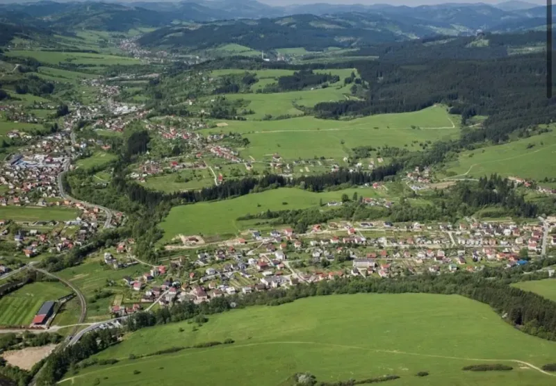 Letecký pohled na zemědělské a lesní pozemky v Olešné s viditelnou zástavbou.