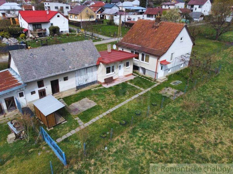 Rodinný dům ve Volici s dvorem, přístavbou a zahradou, obklopený dalšími domy.