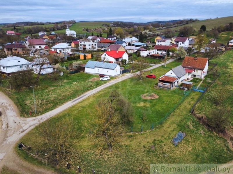 Exteriér rodinných domů ve Volici s venkovskou architekturou na zelených kopcích.