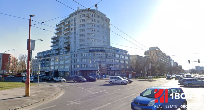Budova na Tomášikově ulici v Bratislavě - Ružinově, rušná křižovatka a provoz.