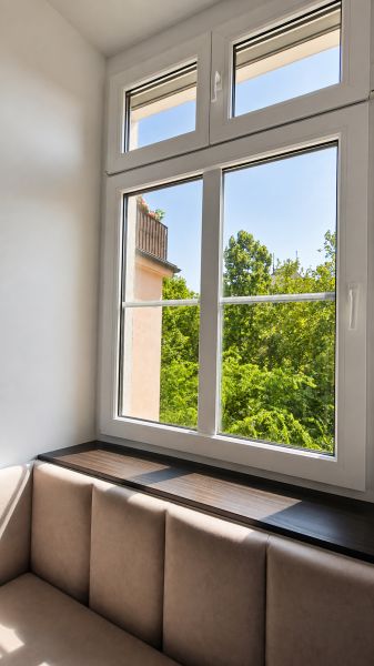 Světlá místnost s pohodlným sezením a velkým oknem, 2-pokojový byt.