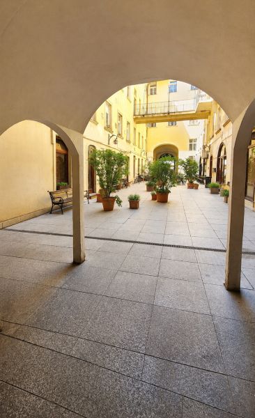 Podloubí s oblouky a květináči na Hviezdoslavově náměstí v Bratislavě - Starém Městě.