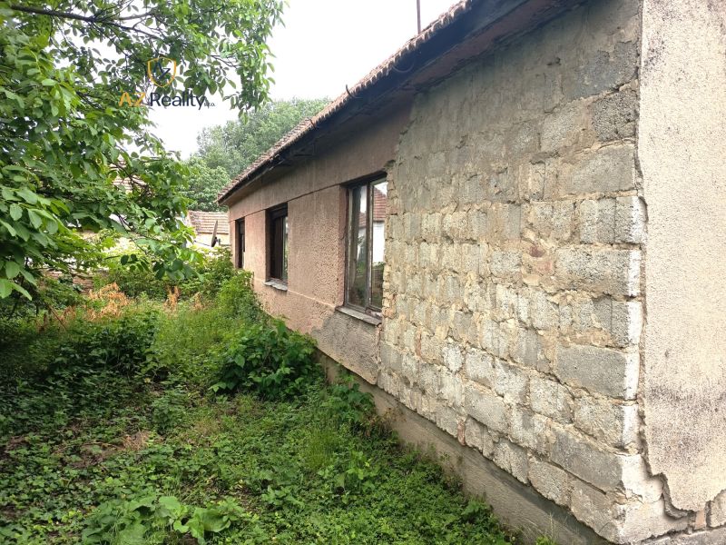 Starší rodinný dům v Nových Zámcích s neudržovanou zahradou a dřevěnou střešní konstrukcí.