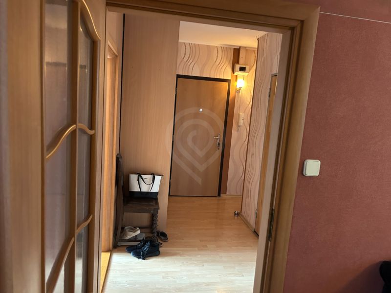Chodba ve 3-pokojovém bytě s podlahou s dřevěným dekorem.