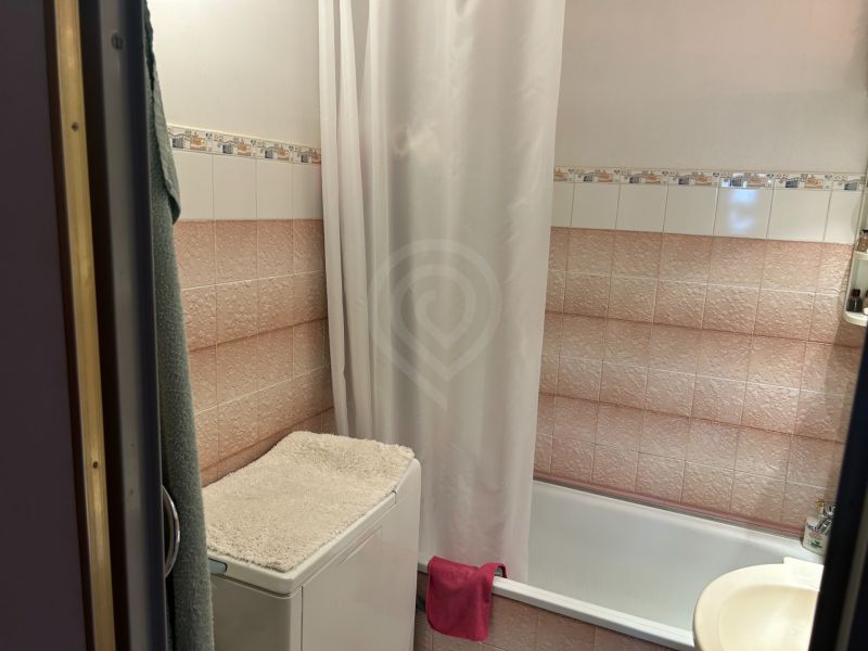 Koupelna s vanou, pračka s ručníkem a obklady v 3-pokojovém bytě.