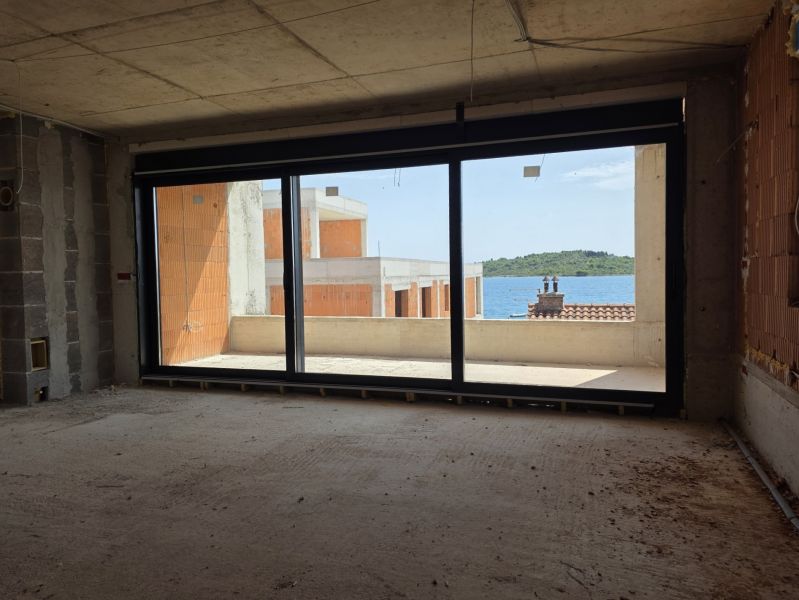 Nedokončený interiér 3-pokojového bytu s výhledem na moře a balkonem.