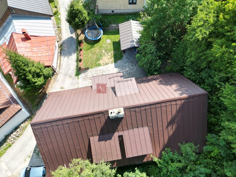 Letecký pohled na Chatu ve Španí Dolině v Banské Bystrici s trampolínou na dvoře.